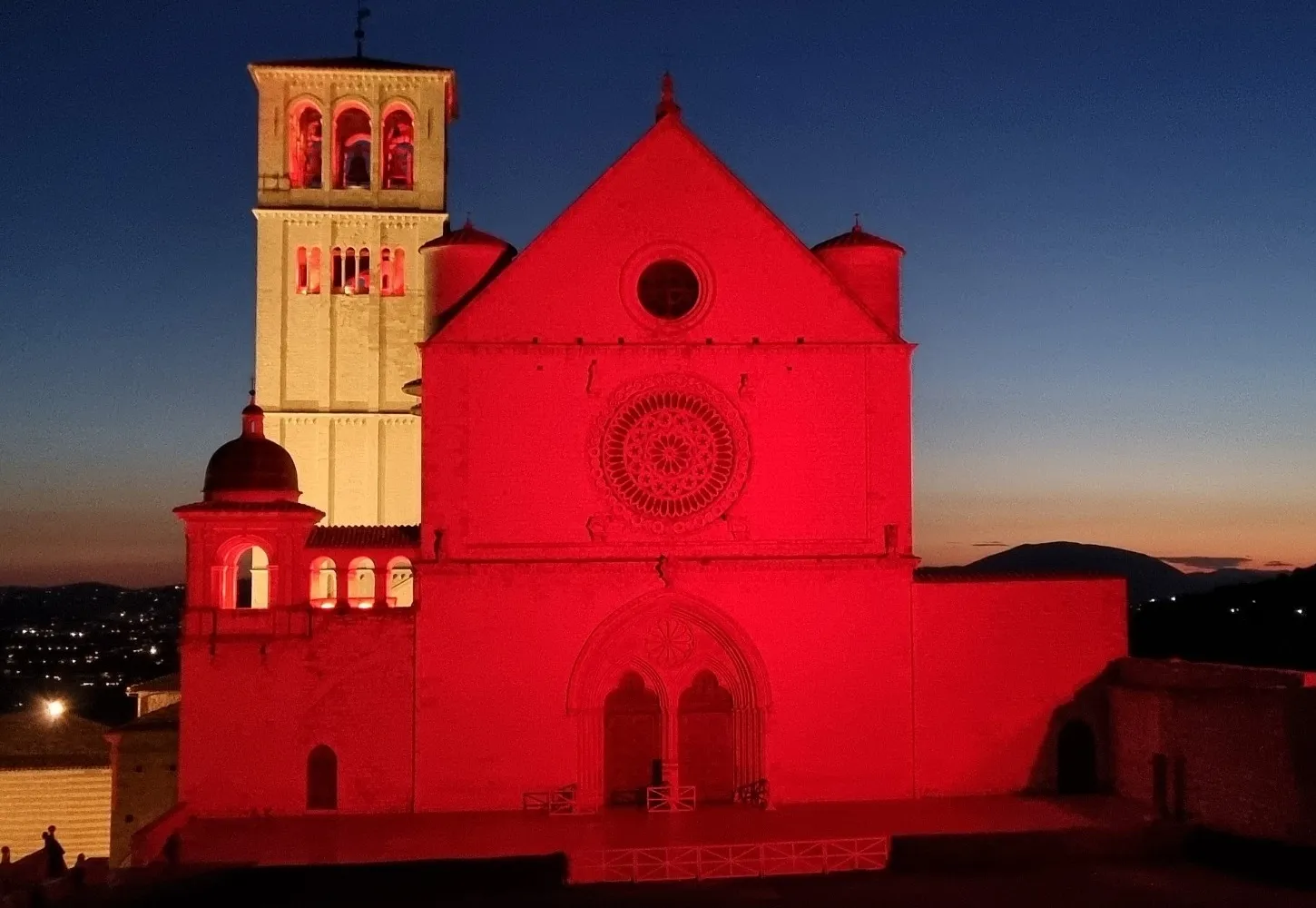 La basilica di Assisi illuminata di rosso