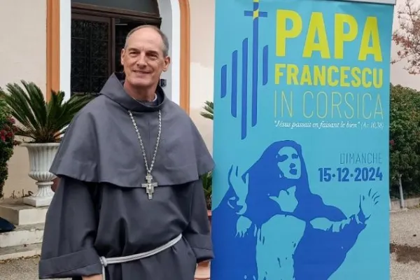 Il cardinale Bustillo con il logo del viaggio di Papa Francesco in Corsica / Vatican News